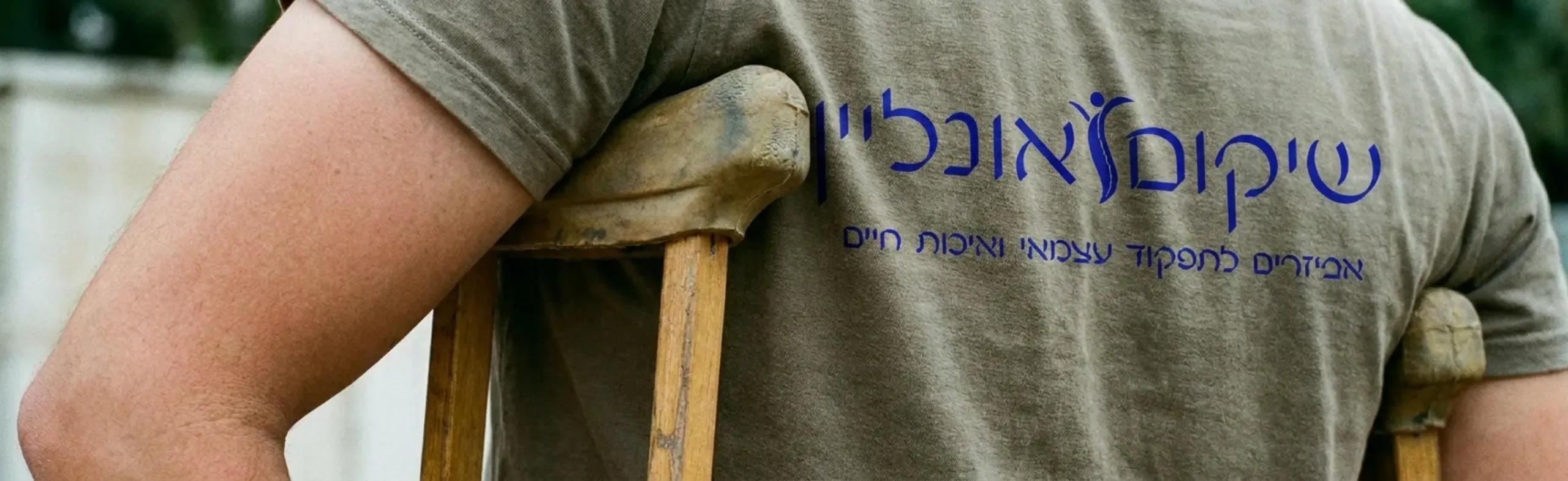 צילום תקריב איכותי של אדם הנשען על קביים של בית השחי. התמונה מראה בבירור מרווח של כשתיים עד שלוש אצבעות בין כרית הקב העליונה לבין בית השחי עצמו, למניעת לחץ על אזור העצבים, יחד עם זווית כיפוף קלה של המרפקים סביב ידיות האחיזה
